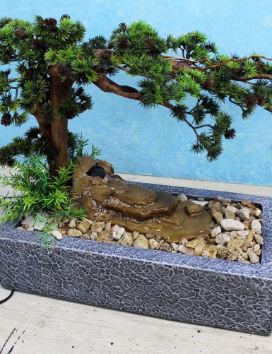 Dieser Zimmerbrunnen besteht aus Natursteinen und künstlichen Pflanzen.